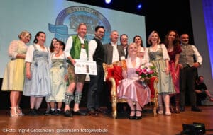 Die Bayerische Bierkönigin 2026/2027 Katharina Kastenmüller mit Staatsminister Hubert Aiwanger, Designerin Elisa Berzaghi-Freymann (Spieth & Wensky), Brauer-Präsident Dr. Stefan Kreisz, Roland de Witt (Businesspartner), den Finalistinnen und Voting-Kandidatinnen sowie der Bayerischen Bierkönigin 2025/2026 Anna Winkler (©Foto: Ingrid Grossmann)